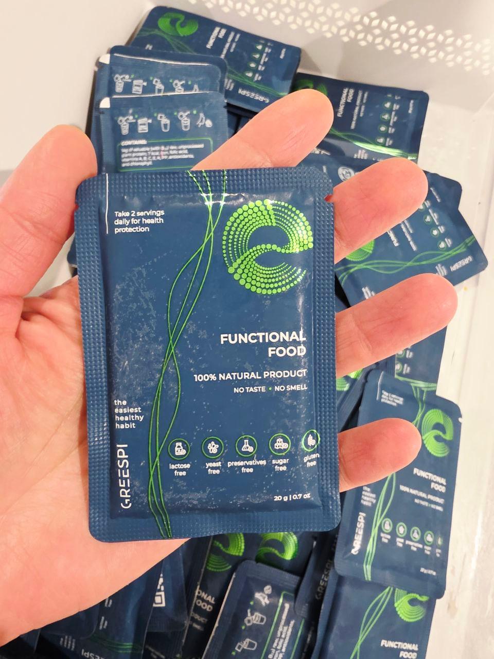 Greespi sachet emerging from a freezer, thermobox nearby — warm, editorial